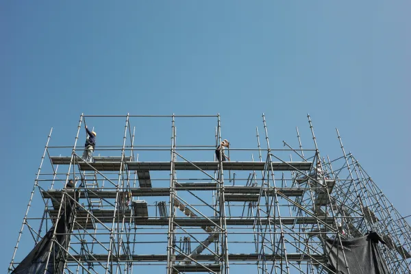 Construction workers efficiently assembling galvanized ringlock scaffold using wedge pin connections Construction workers efficiently assembling galvanized ringlock scaffold using wedge pin connections